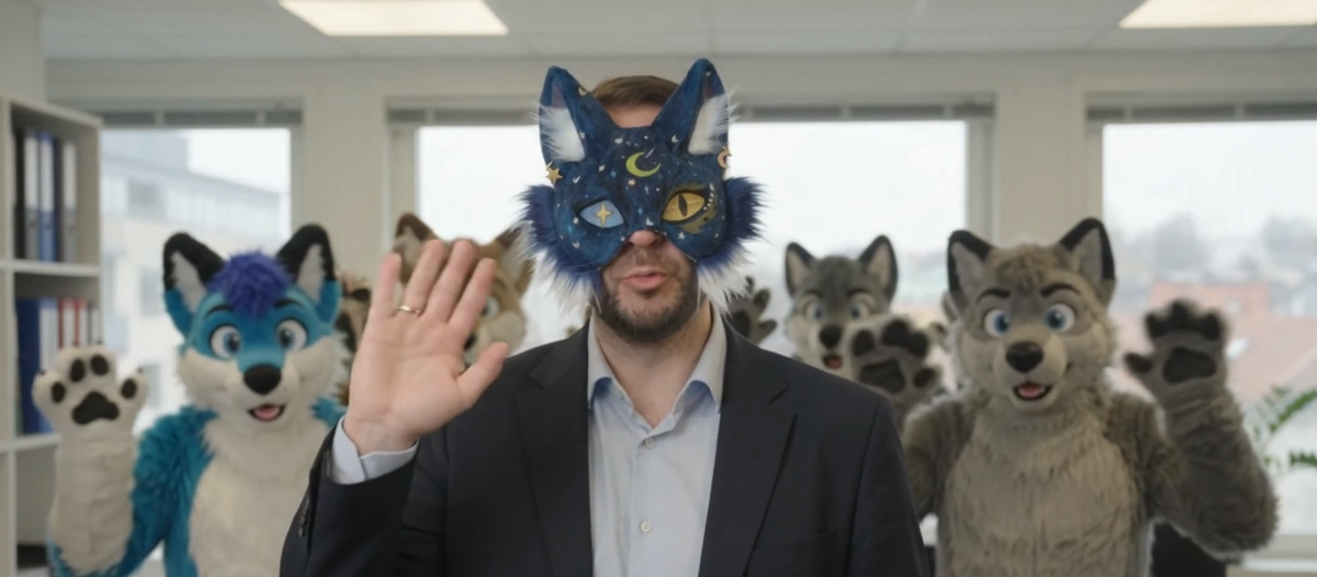 Øystein Holt i therian-maske vinker, med furries fra forbundet bak seg
